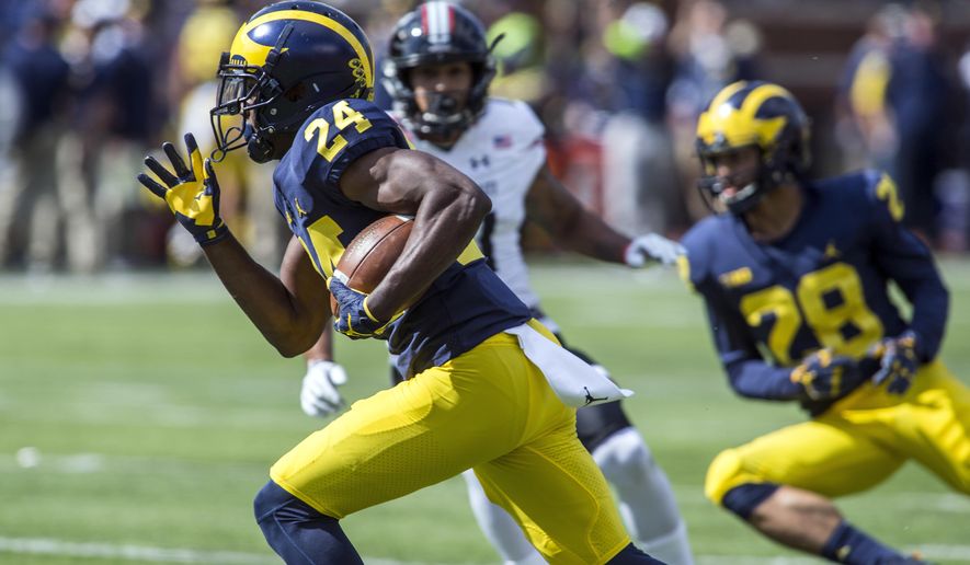 Michigan defensive back Lavert Hill (24) returns an interception for a touchdown in the fourth quarter of an NCAA college football game against Cincinnati in Ann Arbor, Mich., Saturday, Sept. 9, 2017. Michigan won 36-14. (AP Photo/Tony Ding)