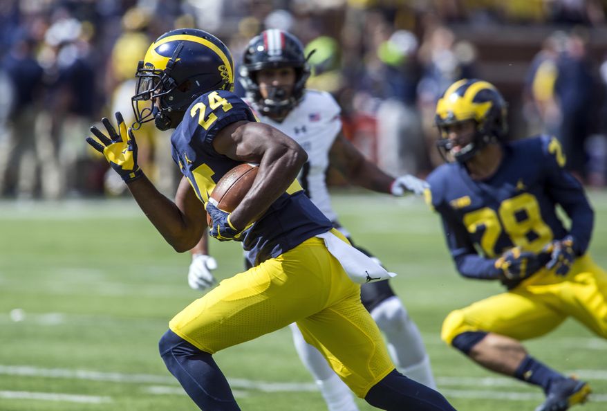 Michigan defensive back Lavert Hill (24) returns an interception for a touchdown in the fourth quarter of an NCAA college football game against Cincinnati in Ann Arbor, Mich., Saturday, Sept. 9, 2017. Michigan won 36-14. (AP Photo/Tony Ding)