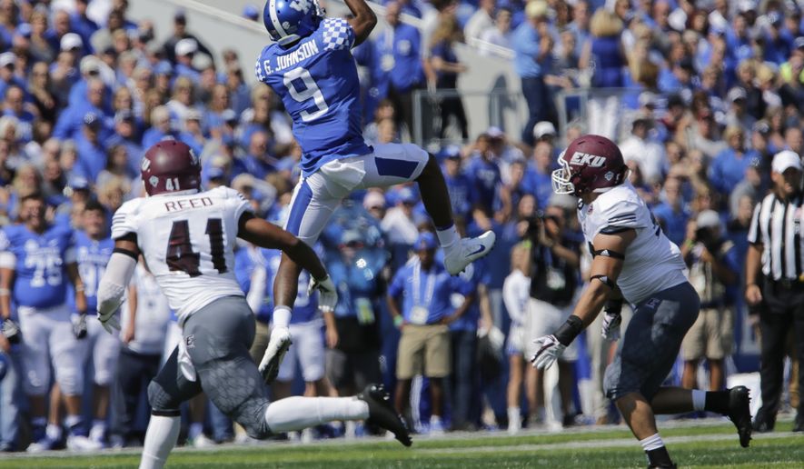 Kentucky's Garrett Johnson catches a first down pass in front of Eastern Kentucky's Eric Reed, left, and Jeffrey Canady during the first half of an NCAA college football game Saturday, Sept. 9, 2017, in Lexington, Ky. (AP Photo/David Stephenson)