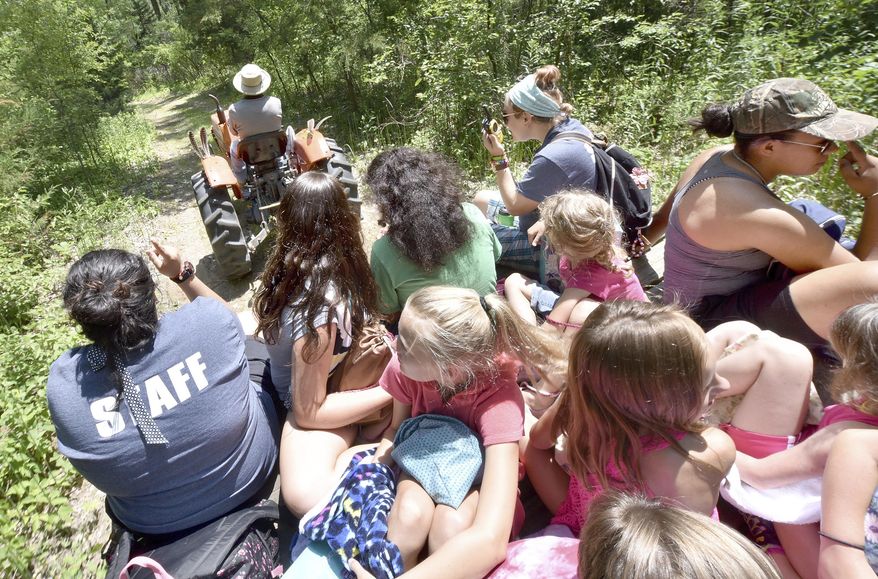 Sefrino Villanueva drives a trailer full of campers and staff members to a canoe pond on June 28, 2016, at Camp Goodwill in South Sioux City, Neb. The Goodwill of the Great Plains has been operating the camp since 1927. (Tim Hynds /Sioux City Journal via AP)