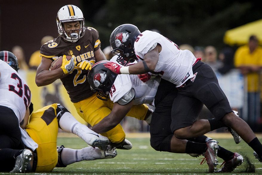 Wyoming running back Kellen Overstreet (29) is hit by Gardner-Webb's Josh Ramseur (93) during an NCAA college football game Saturday, Sept. 9, 2017, in Laramie, Wyo. (Josh Galemore/The Casper Star-Tribune via AP)