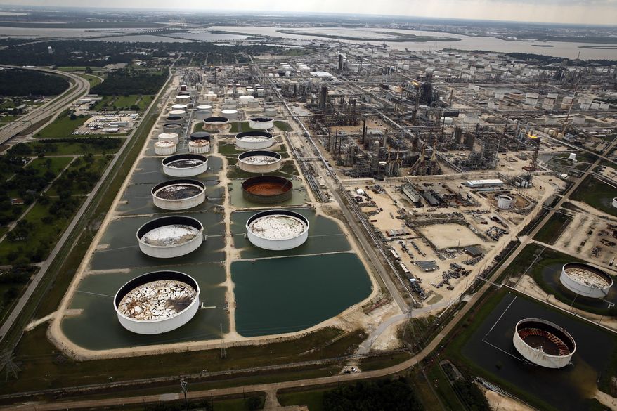 FILE - In this Wednesday, Aug. 30, 2017 file photo, large storage tanks situated in retention ponds are surrounded by rainwater left behind by Tropical Storm Harvey at ExxonMobil's refinery in Baytown, Texas. Companies have reported that roughly two dozen storage tanks holding crude oil, gasoline and other fuels collapsed or otherwise failed during Harvey, spilling a combined 140,000 gallons of fuel, according to an Associated Press analysis of state and federal accident databases. Federal rules require companies to be prepared for spills, but don't require them to take any specific measures to secure the massive fuel storage tanks at refineries and oil production sites that are prone to float and break during floods. (Tom Fox/The Dallas Morning News via AP, file)