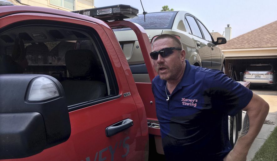 In this Wednesday, Sept. 6, 2017, photo, Bryan Harvey of Harvey&#x27;s Towing in Rosenberg, Texas, tows a flooded car in the nearby town of Katy. Following the record flooding brought on by Hurricane Harvey, tow companies have hauled hundreds of thousands of water-logged vehicles. The storm inflicted an automotive catastrophe on a car-centric city whose dependence on vehicles is likely to slow its recovery. (AP Photo/Scott Mayerowitz)