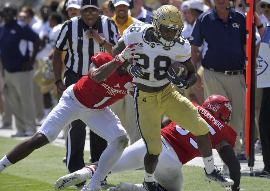 Georgia Tech running back J.J. Green (28) runs down the sidelines until he is pushed out by Jacksonville State safety Marlon Bridges (1) during the first half of an NCAA college football game, Saturday, Sept. 9, 2017 in Atlanta. Georgia Tech defeated Jacksonville State. 37-10. (Hyosub Shin/Atlanta Journal-Constitution via AP)