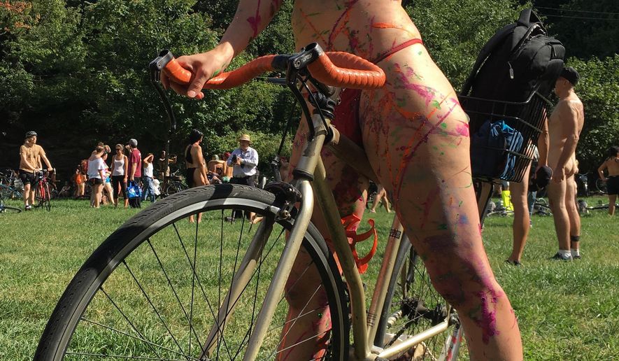 Olivia Neely, a topless cyclist wearing body paint, motions before the start of the annual Philly Naked Bike Ride in Philadelphia on Saturday Sept. 9, 2017. (AP Photo/Dino Hazell)