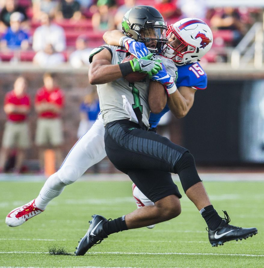 SMU defensive back Jordan Wyatt (15) tackles North Texas wide receiver Turner Smiley (1) during the first quarter of an NCAA college football game, Saturday, Sept. 9, 2017 at SMU's Ford Stadium in Dallas. (Ashley Landis/The Dallas Morning News via AP)