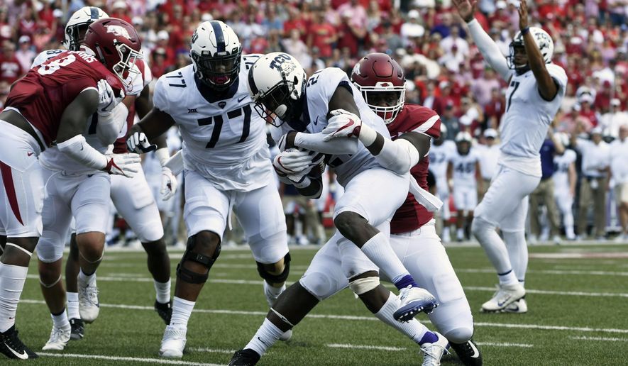 TCU running back Kyle Hicks slips past Arkansas defender Armon Watts to score a touchdown in the first half of an NCAA college football game in Fayetteville, Ark., Saturday, Sept. 9, 2017. (AP Photo/Michael Woods)