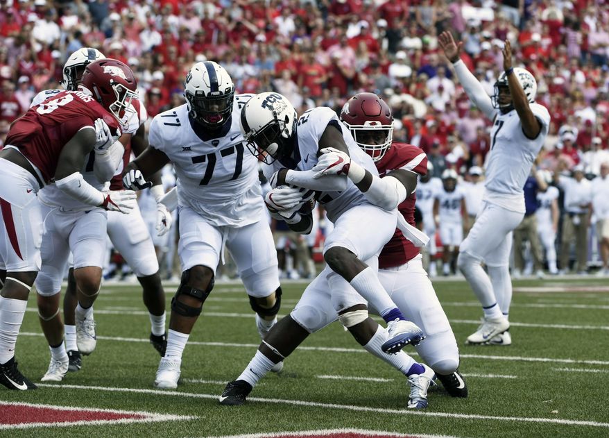 TCU running back Kyle Hicks slips past Arkansas defender Armon Watts to score a touchdown in the first half of an NCAA college football game in Fayetteville, Ark., Saturday, Sept. 9, 2017. (AP Photo/Michael Woods)
