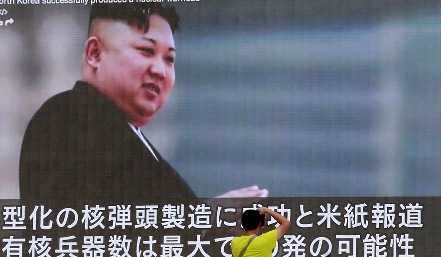 FILE - In this Aug. 6, 2017, file photo, a man takes a photo of a TV news program in Tokyo, showing an image of North Korean leader Kim Jong Un. U.N. experts say North Korea illegally exported coal, iron and other commodities worth at least $270 million to China and other countries including India, Malaysia and Sri Lanka during the six-month period ending in August in violation of U.N. sanctions. (AP Photo/Shizuo Kambayashi, File)