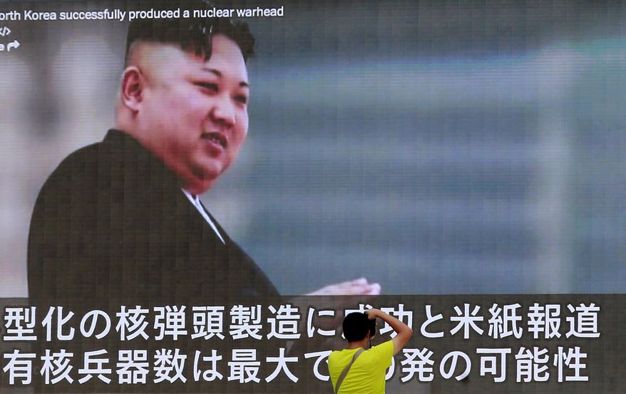 FILE - In this Aug. 6, 2017, file photo, a man takes a photo of a TV news program in Tokyo, showing an image of North Korean leader Kim Jong Un. U.N. experts say North Korea illegally exported coal, iron and other commodities worth at least $270 million to China and other countries including India, Malaysia and Sri Lanka during the six-month period ending in August in violation of U.N. sanctions. (AP Photo/Shizuo Kambayashi, File)