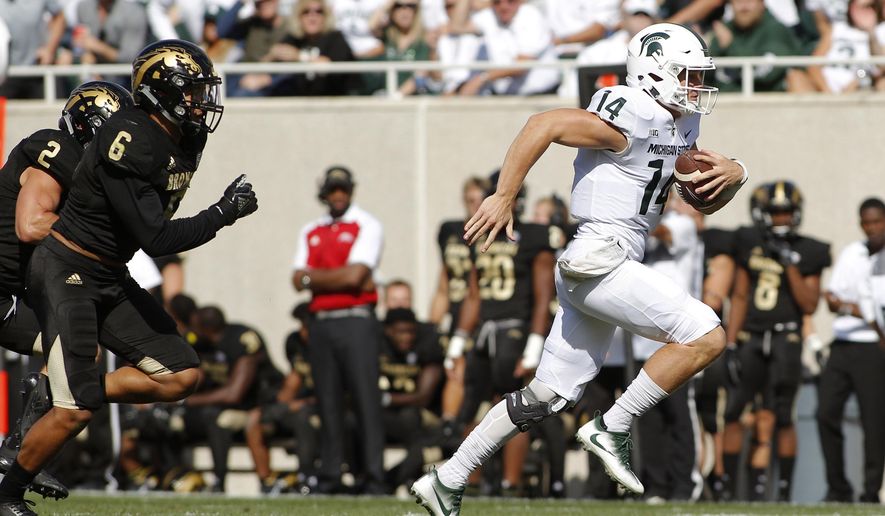 Michigan State quarterback Brian Lewerke, right, gets away from Western Michigan's Asantay Brown (6), and Justin Tranquill (2) to scores a 61-yard rushing touchdown during the first quarter of an NCAA college football game, Saturday, Sept. 9, 2017, in East Lansing, Mich. (AP Photo/Al Goldis)