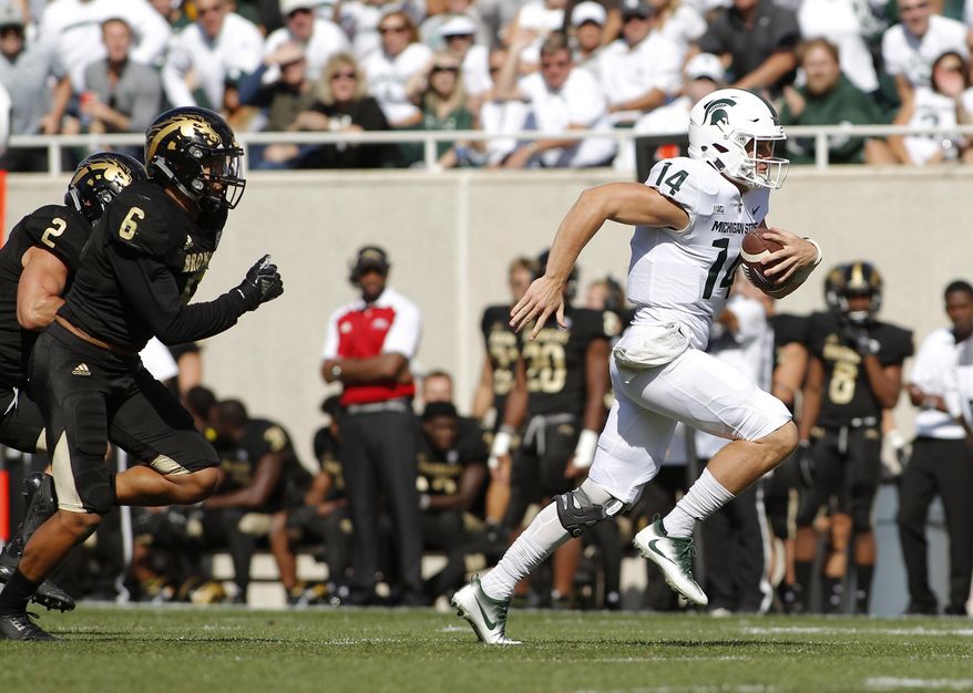 Michigan State quarterback Brian Lewerke, right, gets away from Western Michigan's Asantay Brown (6), and Justin Tranquill (2) to scores a 61-yard rushing touchdown during the first quarter of an NCAA college football game, Saturday, Sept. 9, 2017, in East Lansing, Mich. (AP Photo/Al Goldis)