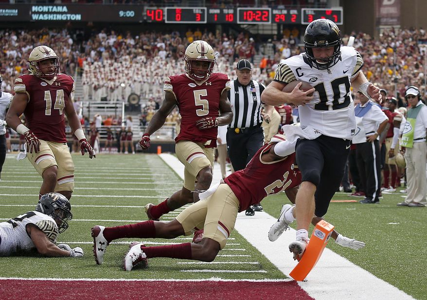 Wake Forest quarterback John Wolford (10) rushes for a touchdown past the tackle attempt from Boston College defensive back Lukas Denis (21) during the first half of an NCAA college football game, Saturday, Sept. 9, 2017, in Boston. (AP Photo/Mary Schwalm)
