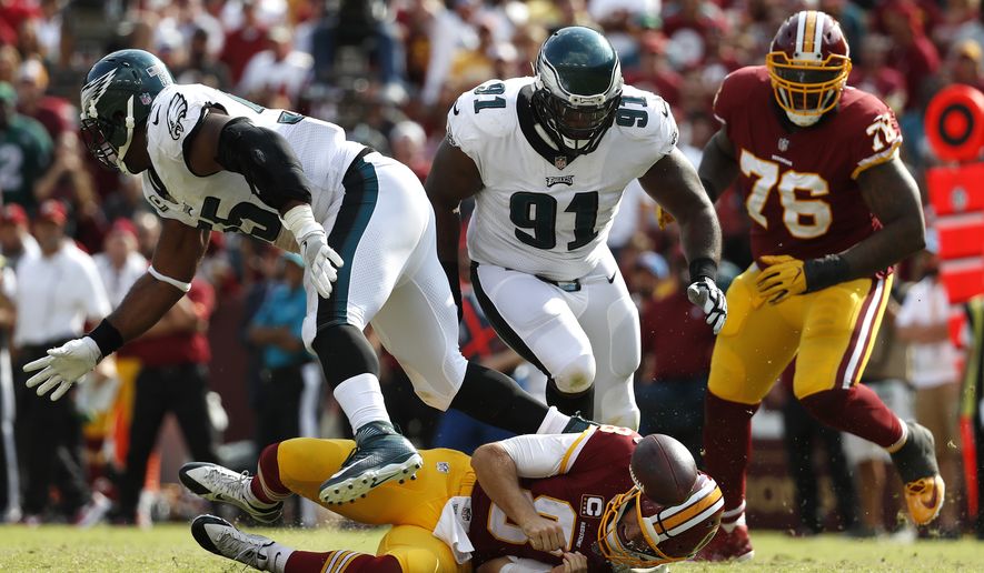 Washington Redskins quarterback Kirk Cousins, bottom, fumbles in front of Philadelphia Eagles defensive tackle Fletcher Cox (91), defensive end Brandon Graham, left, and Redskins offensive tackle Morgan Moses (76) in the second half of an NFL football game, Sunday, Sept. 10, 2017, in Landover, Md. Cox recovered the fumble and scored a touchdown on the play. Philadelphia won 30-17. (AP Photo/Alex Brandon)