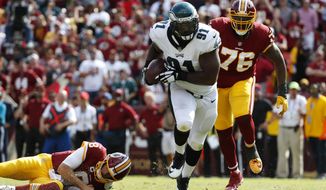 Philadelphia Eagles defensive tackle Fletcher Cox, center, rushes for a touchdown in front of Washington Redskins offensive tackle Morgan Moses (76) after recovering a fumble by Redskins quarterback Kirk Cousins, bottom left, in the second half of an NFL football game, Sunday, Sept. 10, 2017, in Landover, Md. Philadelphia won 30-17. (AP Photo/Alex Brandon)
