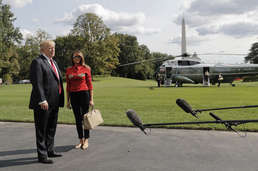 President Donald Trump stops to answers questions, accompanied by first lady Melania Trump, on at South Lawn of the White House in Washington, Sunday, Sept. 10, 2017. Trump commented on the response to Hurricane Irma which he called "some big monster," and praised both FEMA and the Coast Guard for their efforts as the storm made landfall. (AP Photo/Pablo Martinez Monsivais)