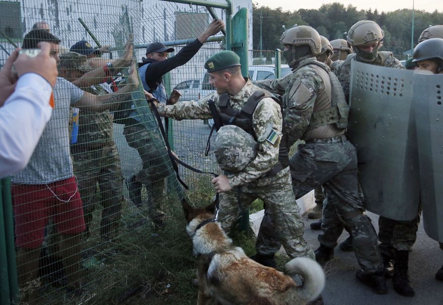 Supporters of the Former Georgian President and former Ukraine official Mikheil Saakashvili clash with border guards at Shegini check point on Ukrainian-Polish border, Ukraine, Sunday, Sept. 10, 2017. Saakashvili and a crowd of supporters are proceeding into Ukraine on foot after breaking through a line of guards on the Polish-Ukrainian border. (AP Photo/Efrem Lukatsky)