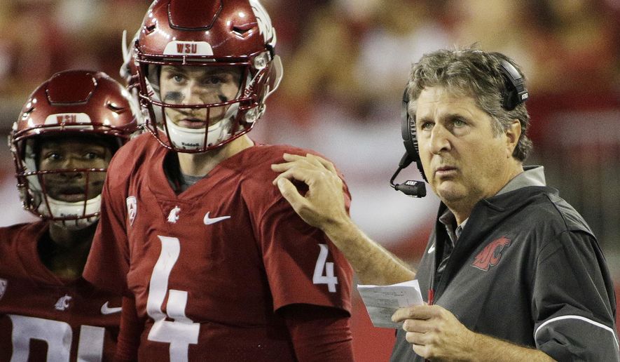 Washington State coach Mike Leach, right, speaks with quarterback Luke Falk during the first half of an NCAA college football game against Boise State in Pullman, Wash., Saturday, Sept. 9, 2017. (AP Photo/Young Kwak)