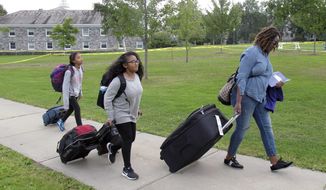 In this Aug. 31, 2017 photo, first generation college student Minori Kawano, of New York, center, arrives at Middlebury College accompanied by her mother, Mercy Kawano, right, and younger sister Mayomi Kawano, left, in Middlebury, Vt. The school is among a number of colleges and universities across the country with special programs to help ease the transition to college for students who are the first in their families to attend. (AP Photo/Wilson Ring)