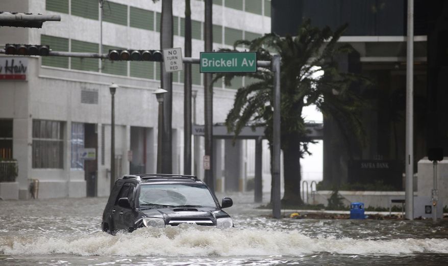 A vehicle drives on flooded Brickell Avenue in Miami on Sunday, Sept. 10, 2017, as Hurricane Irma passes. (Mike Stocker/South Florida Sun-Sentinel via AP)