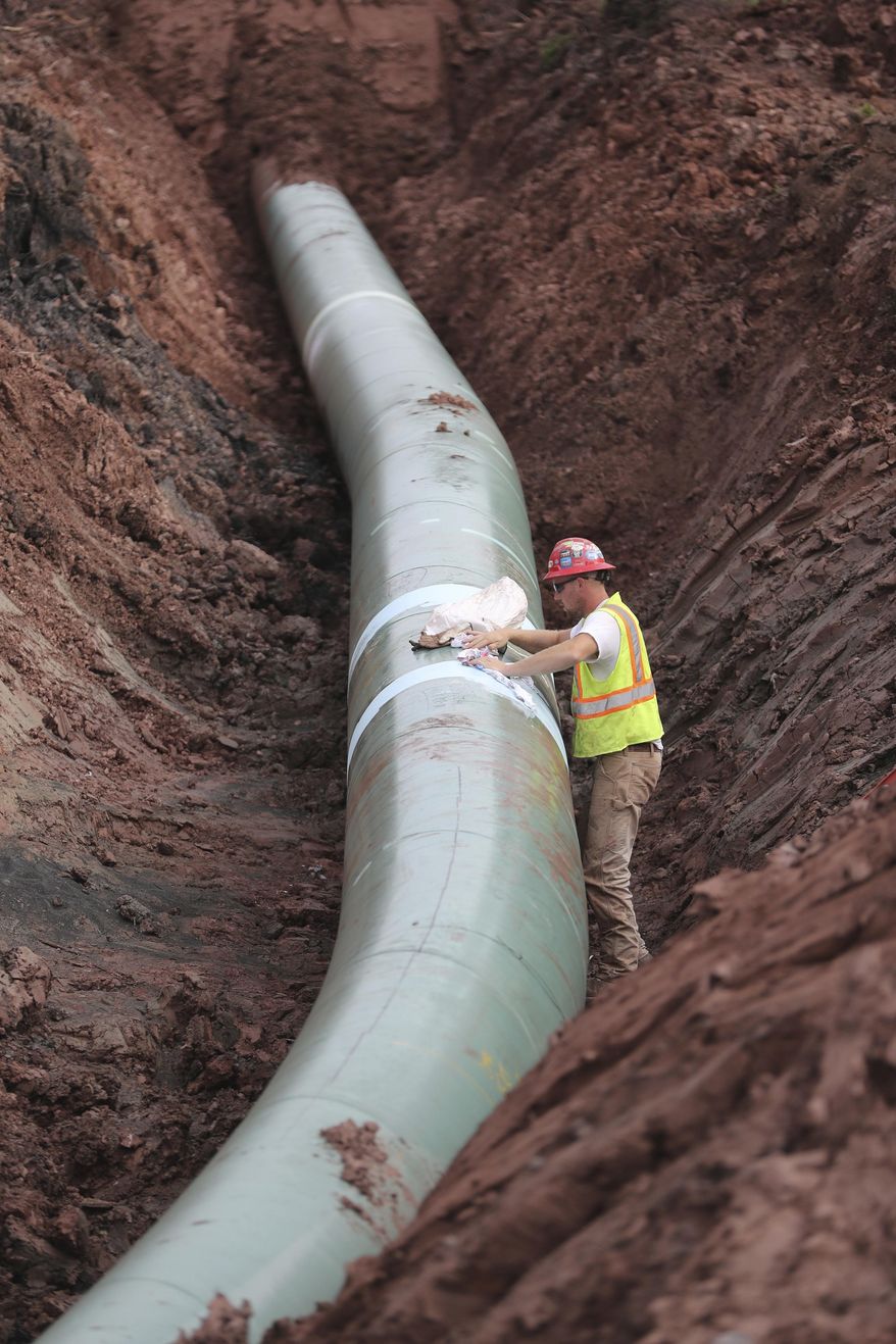 In an Aug. 21, 2017 photo, a pipe fitter lays the finish finishing touches to the replacement of Line 3 stretch before it is covered up. Enbridge already has started building the 14-mile stretch of Line 3 from the Minnesota line to its terminal in Superior, Wis. In filings with the Public Utilities Commission Monday, Sept. 11, The Minnesota Department of Commerce says Enbridge Energy has failed to establish the need for its proposal to replace its aging Line 3 crude oil pipeline across northern Minnesota. Instead, the department says it might be better to just shut down the existing line.  (Richard Tsong-Taatarii/Star Tribune via AP)