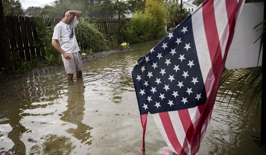 Tybee Island resident Joe Murphy wipes the sweat off his face while standing in knee deep water from Tropical Storm Irma outside his house, Monday, Sept., 11, 2017, on Tybee Island, Ga. (AP Photo/Stephen B. Morton)