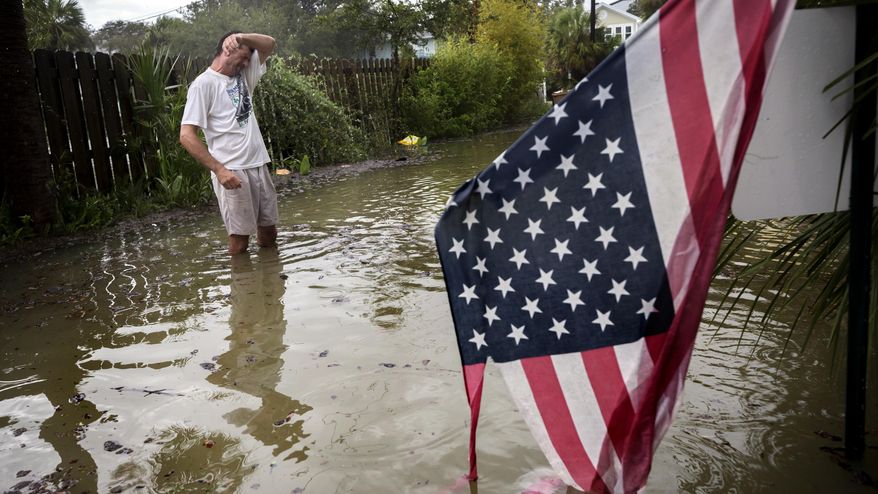Tybee Island resident Joe Murphy wipes the sweat off his face while standing in knee deep water from Tropical Storm Irma outside his house, Monday, Sept., 11, 2017, on Tybee Island, Ga. (AP Photo/Stephen B. Morton)