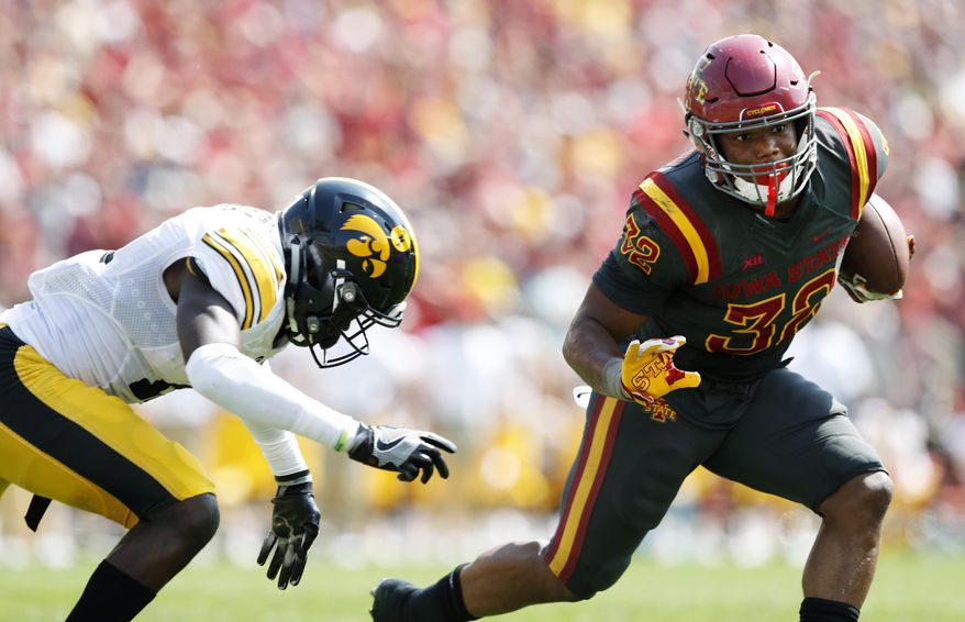 Iowa State running back David Montgomery (32) runs from Iowa defensive back Michael Ojemudia, left, during the second half of an NCAA college football game, Saturday, Sept. 9, 2017, in Ames, Iowa. Iowa won 44-41 in overtime. (AP Photo/Charlie Neibergall)