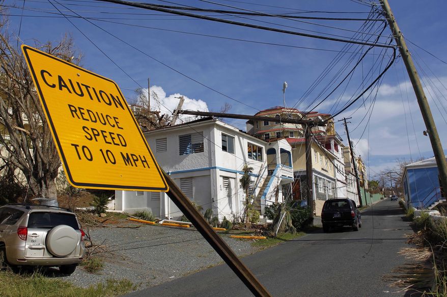A speed limit sign stands tilted and a power line that snapped it half lays on a building, after the passage of Hurricane Irma in Charlotte Amalie, St. Thomas, U.S. Virgin Islands, Sunday, Sept. 10, 2017. The storm ravaged such lush resort islands as St. Martin, St. Barts, St. Thomas, Barbuda and Anguilla. (AP Photo/Ricardo Arduengo)