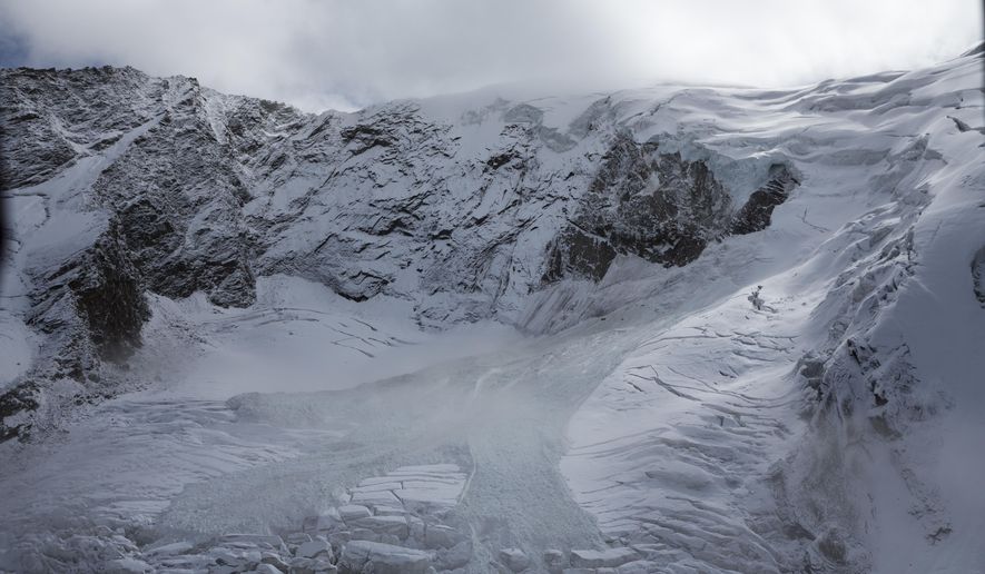 The glacial ice avalanche of the Trift Glacier above the village is pictured this morning in Saas-Grund, Valais, Switzerland, Sunday, Sept. 10, 2017. Part of the glacier has broken off and tumbled onto a glacier below after some 220 people in a small nearby town were evacuated as a precaution. (Dominic Steinmann/Keystone via AP)