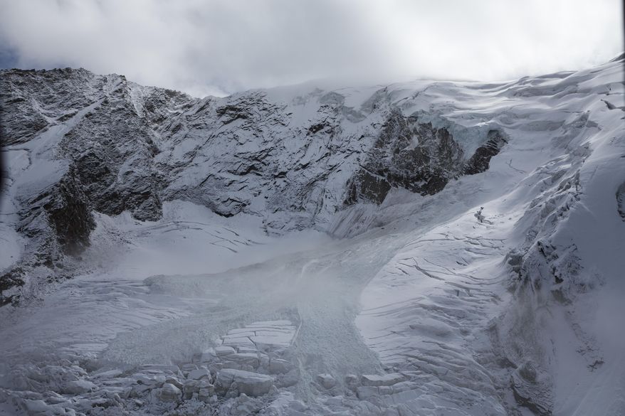 The glacial ice avalanche of the Trift Glacier above the village is pictured this morning in Saas-Grund, Valais, Switzerland, Sunday, Sept. 10, 2017. Part of the glacier has broken off and tumbled onto a glacier below after some 220 people in a small nearby town were evacuated as a precaution. (Dominic Steinmann/Keystone via AP)
