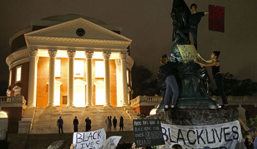 Black Lives Matter protesters cover a statue of Thomas Jefferson with a tarp during a rally in front of the Rotunda at the University of Virginia on Tuesday. (Photo by Zack Wajsgras/The [Charlottesville, Va.] Daily Progress)