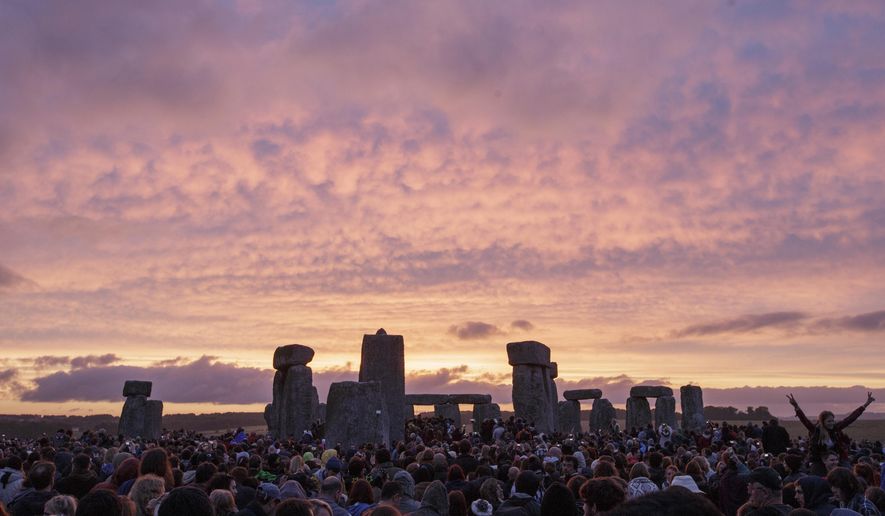 FILE - In this Sunday, June 21, 2015 file photo, the sun rises as thousands of revellers gather at the ancient stone circle Stonehenge to celebrate the Summer Solstice, the longest day of the year, near Salisbury, England. British authorities have approved a contentious road tunnel under Stonehenge _ but have altered its route so it doesn&#39;t impede views of the sun during the winter solstice, it was reported on Tuesday, Sept. 12, 2017. (AP Photo/Tim Ireland, File)