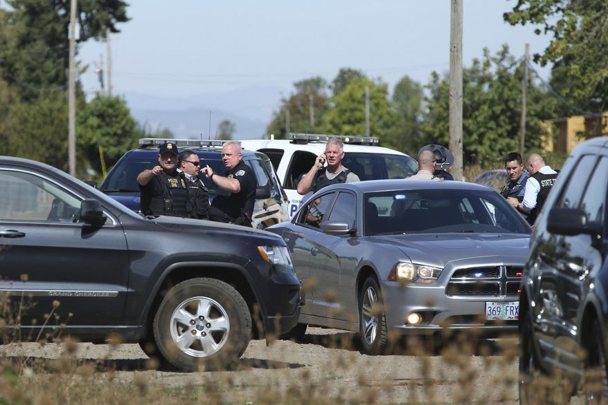 Law enforcement agencies stage along Hwy 99 and Davisson Rd south or Creswell, Ore., after an officer involved shooting on Tuesday, Sept. 12, 2017. (Collin Andrew/The Register-Guard)