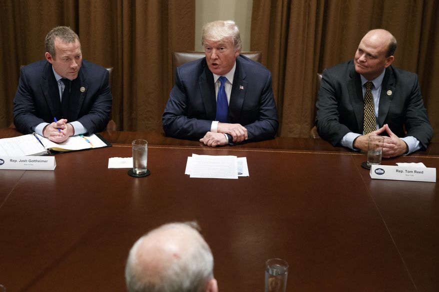 Rep. Josh Gottheimer, D-N.J., left, and Rep. Tom Reed, R-N.Y., right, listen as President Donald Trump speaks during a meeting with a bipartisan group of lawmakers in the Cabinet Room of the White House, Wednesday, Sept. 13, 2017, in Washington. (AP Photo/Evan Vucci)