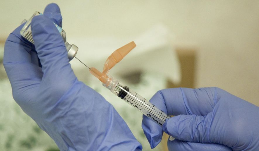 In this Aug. 27, 2010, file photo, a nurse practitioner prepares a flu vaccination in Rockville, Md. (AP Photo/Evan Vucci, File)