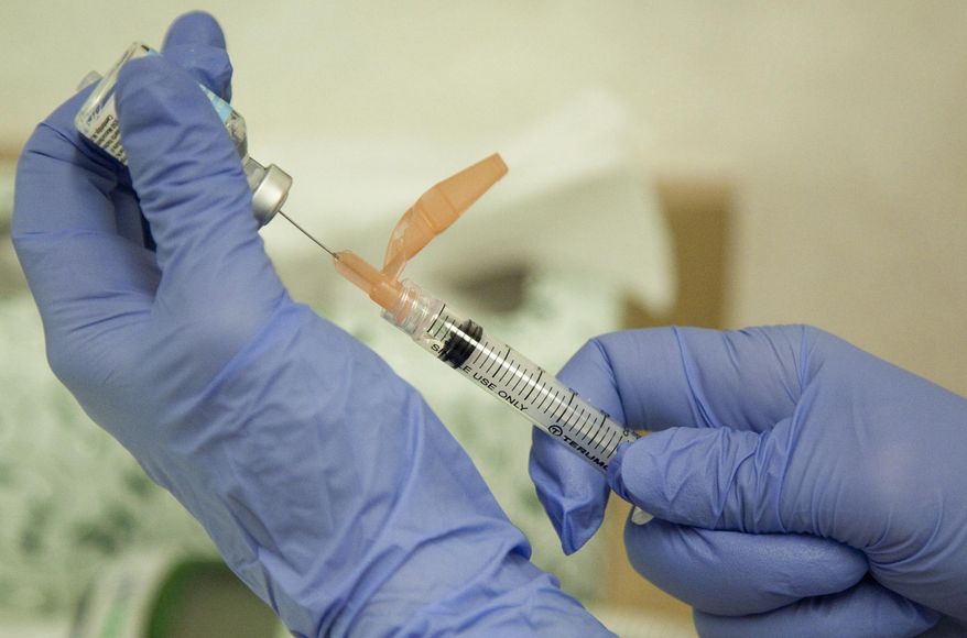 In this Aug. 27, 2010, file photo, a nurse practitioner prepares a flu vaccination in Rockville, Md. (AP Photo/Evan Vucci, File)