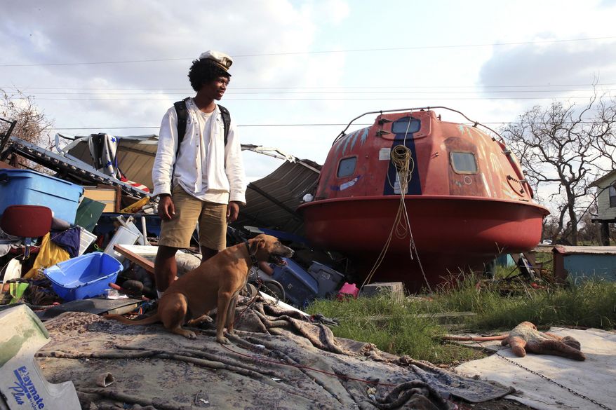 In a Sept. 6, 2017 photo, Davonn Phothiboupha stands near a "hurricane pod" that she stayed in, bought by Linda Caster, a resident of Holiday Beach in Aransas County, Texas, as Hurricane Harvey made landfall. Three people and two dogs stayed inside the pod when Hurricane Harvey made its second landfall with 130 mph winds in Aransas County on Aug. 26. and Phothiboupha said it saved their lives. (Rachel Denny Clow/Corpus Caller-Times, via AP)