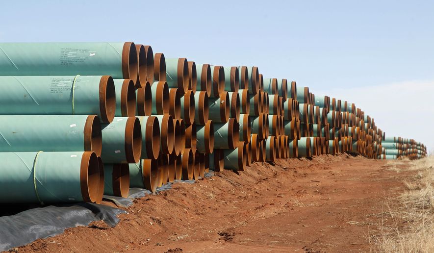 In this Feb. 1, 2012, file photo, miles of pipe ready to become part of the Keystone Pipeline are stacked in a field near Ripley, Okla. (AP Photo/Sue Ogrocki, File)