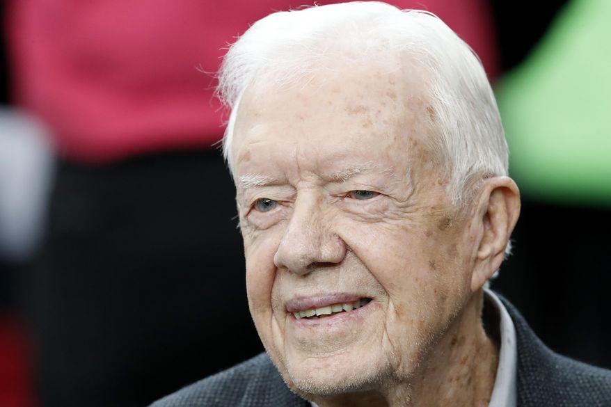 In this Oct. 23, 2016, file photo, former President Jimmy Carter sits on the Atlanta Falcons bench before the first half of an NFL football game between the Atlanta Falcons and the San Diego Chargers, in Atlanta. (AP Photo/John Bazemore, File)