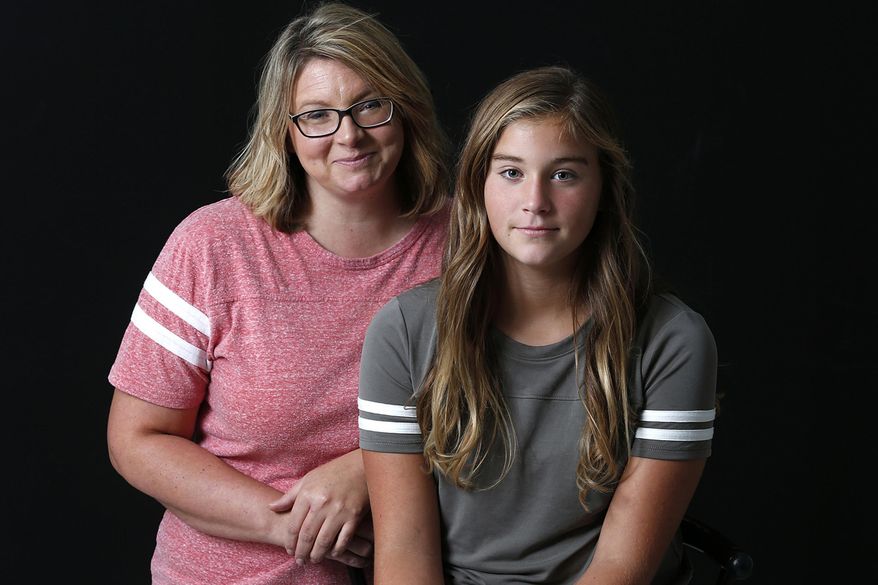 In this Aug. 14, 2017 photo, Jenny, left, and Jade Pebbles of Pleasant Hill, Ill., pose for a photo in Quincy, Ill. Jenny Peebles has a knack for seeing the silver lining in the darkest periods of her life. She has persevered through her parents divorce, the loss of her family home in a fire, the loss her brother to suicide, and a terrifying medical condition that Jade went through. "My family is good now," she said. "My kids are happy. As long as I raise kids that are happy and kind, then I've done a good job." (Jake Shane/The Quincy Herald-Whig via AP)
