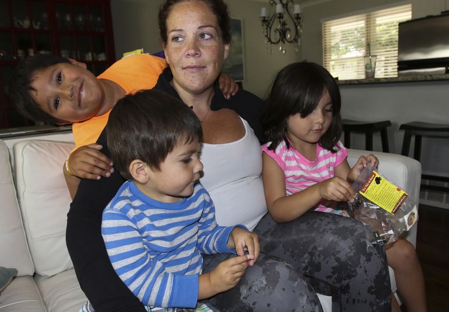 In this Sept. 4, 2017 photo, Colleen Tyrrell Llacas spends time with her three children, Samuel, left, Joshua, center, and Lucy Jane, right, at their home in Naperville, Ill. For more than two years Colleen has been suffering from a cerebral spinal fluid leak, which has caused her a debilitating list of symptoms that initially were misdiagnosed as migraines. (Bev Horne/Daily Herald, via AP)