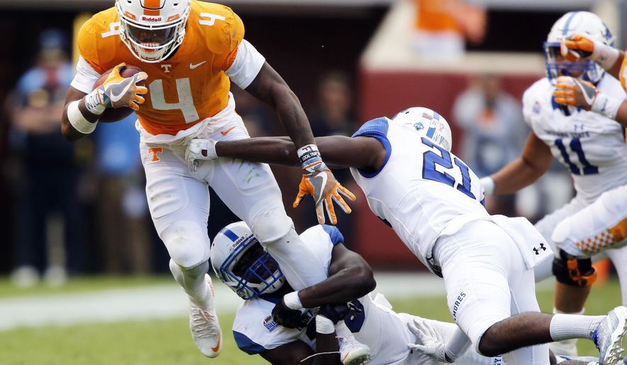 Tennessee running back John Kelly (4) tries to escape the grasp of Indiana State linebacker Jonas Griffith (46) and safety De'Jaun Tyson (21) in the second half of an NCAA college football game, Saturday, Sept. 9, 2017, in Knoxville, Tenn. Tennessee won 42-7. (AP Photo/Wade Payne)