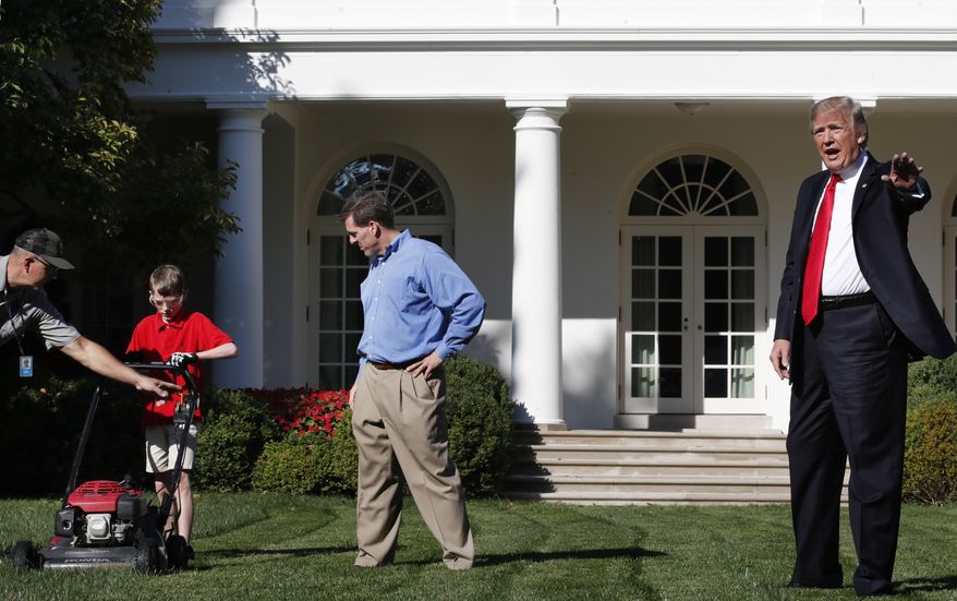 Frank Giaccio, 11, of Falls Church, Va., left, is assisted by a member of the National Park Service, and his father Greg Giaccio, as he gets back to mowing the lawn after President Donald Trump said goodbye, Friday, Sept. 15, 2017, in the Rose Garden at the White House in Washington. The 11-year-old, who wrote the president requesting to mow the lawn at the White House, was so focused on the job at hand the he didn&#39;t notice the president until he was right next to him. (AP Photo/Jacquelyn Martin)