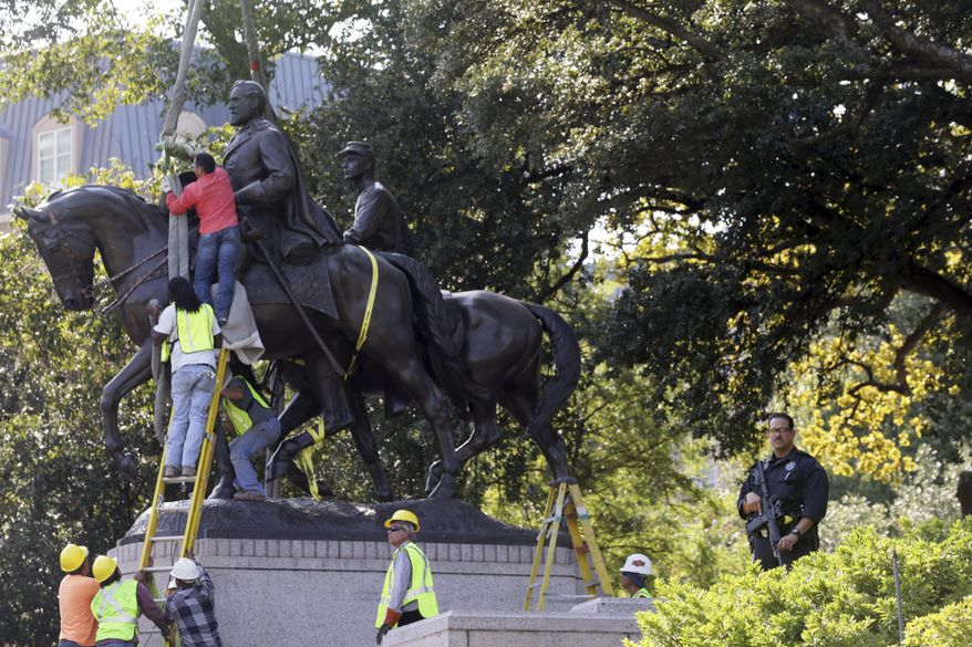 Workers prepare for the removal of a statue of Robert E. Lee at a public park in Dallas, Thursday, Sept. 14, 2017. (AP Photo/LM Otero)