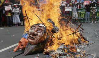 Protesters burn an image of Philippine President Rodrigo Duterte as they tried to march toward U.S. Embassy in Manila, Philippines, Friday, Sept. 15, 2017. The groups is protesting against the alleged increasing intervention of the U.S. military in the ongoing war in Marawi and growing presence in Mindanao. (AP Photo/Aaron Favila)