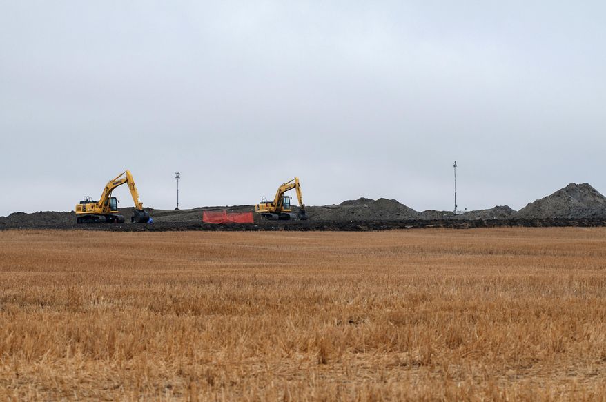 FILE - In this Oct. 11, 2013 file photo, cleanup continues on at the site of an oil pipeline leak and spill north of Tioga, N.D. Four years later, cleanup completion is in sight for the 20,000-barrel oil spill in a North Dakota farmer's field. Excavation of the affected site is scheduled for completion by the end of the month, with a test crop to be planted on the land next spring. The spill from a Tesoro pipeline was discovered by a Tioga farmer in September 2013. It has been called one of the largest onshore spills in U.S. history. (AP Photo/Kevin Cederstrom File)