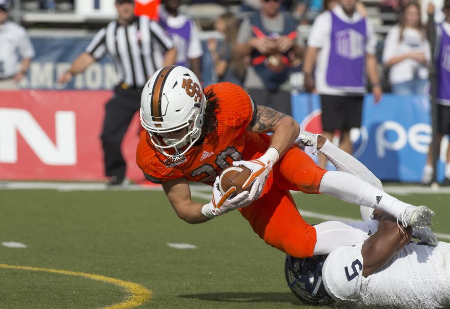 Idaho State's Michael Dean, left, dives for more yardage as he is hit by Nevada' Dameon Baber in the first half of an NCAA college football game in Reno, Nev., Saturday, Sept. 16, 2017. (AP Photo/Tom R. Smedes)