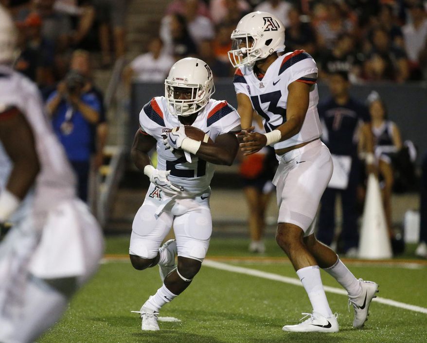 Arizona quarterback Brandon Dawkins hands off the ball to running back J.J. Taylor during an NCAA college football game against UTEP on Friday, Sept. 15, 2017, in El Paso, Texas. (Ruben R. Ramirez/The El Paso Times via AP)