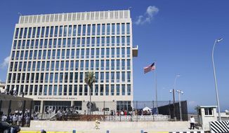 In this Aug. 14, 2015, file photo, a U.S. flag flies at the U.S. embassy in Havana, Cuba. U.S. investigators are chasing many theories about what’s harming American diplomats in Cuba, including a sonic attack, electromagnetic weapon or flawed spying device. (AP Photo/Desmond Boylan) **FILE**